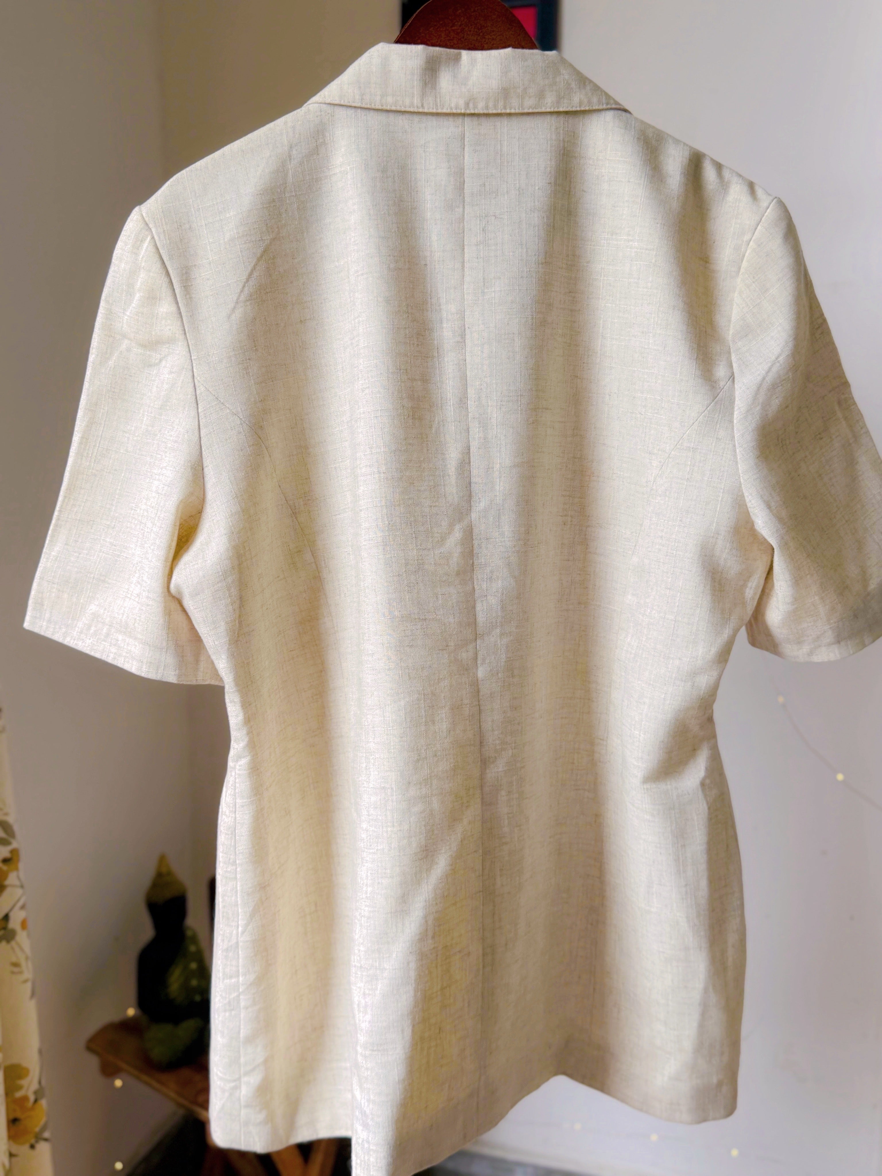 Ivory toned blazer with notched lapels, comes with embroidery work details on the collar.