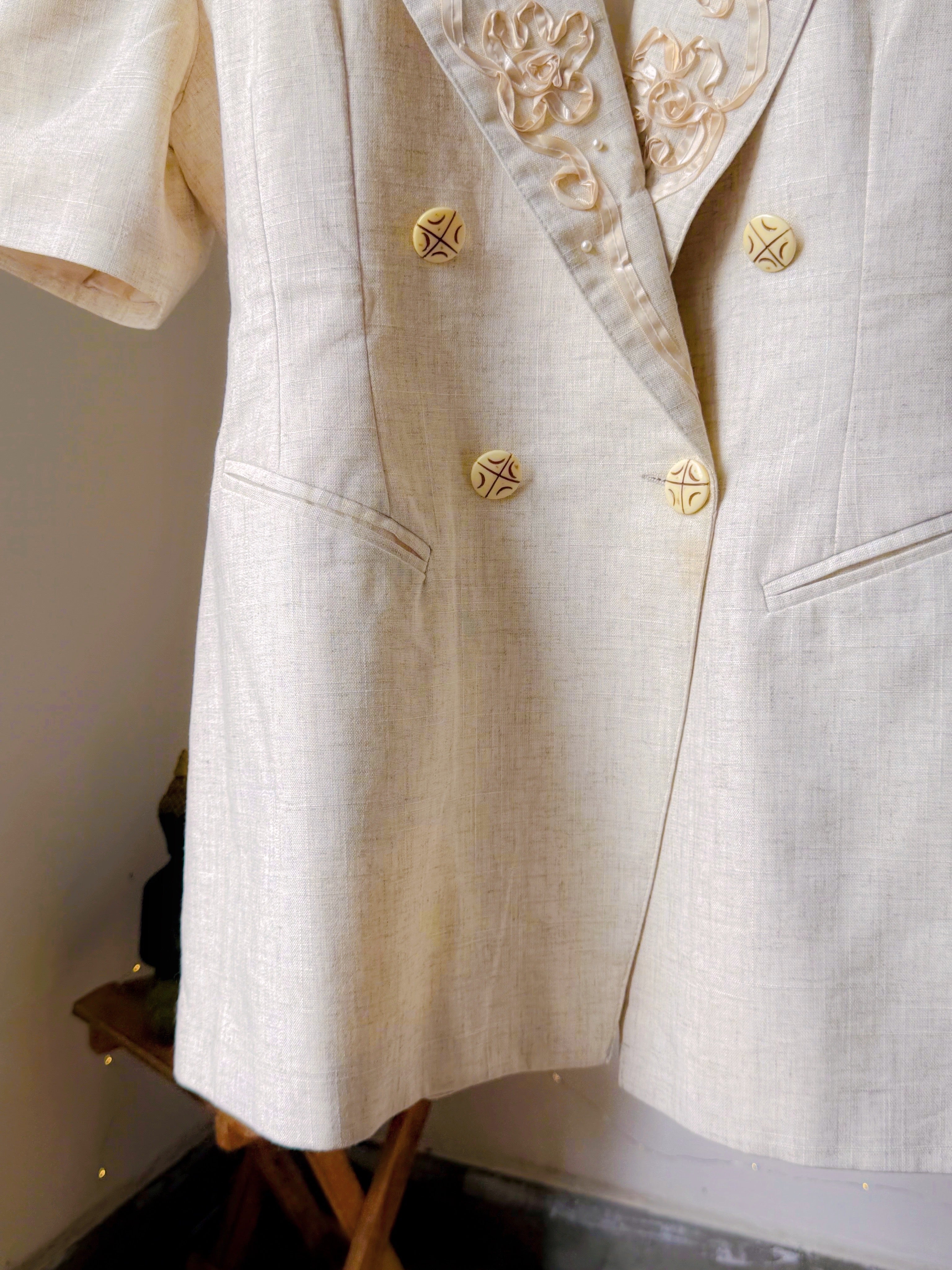 Ivory toned blazer with notched lapels, comes with embroidery work details on the collar.